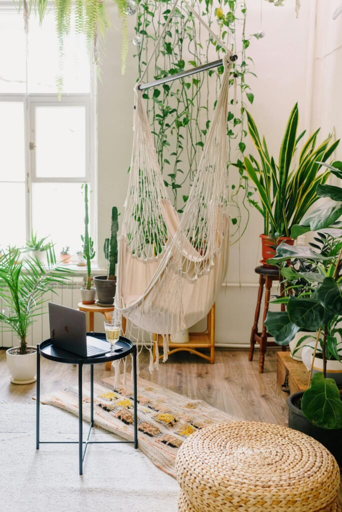 pexels-photo-4740498-4740498 Creative design of living room with comfortable hammock near table with netbook and collection of greenery potted plants at home